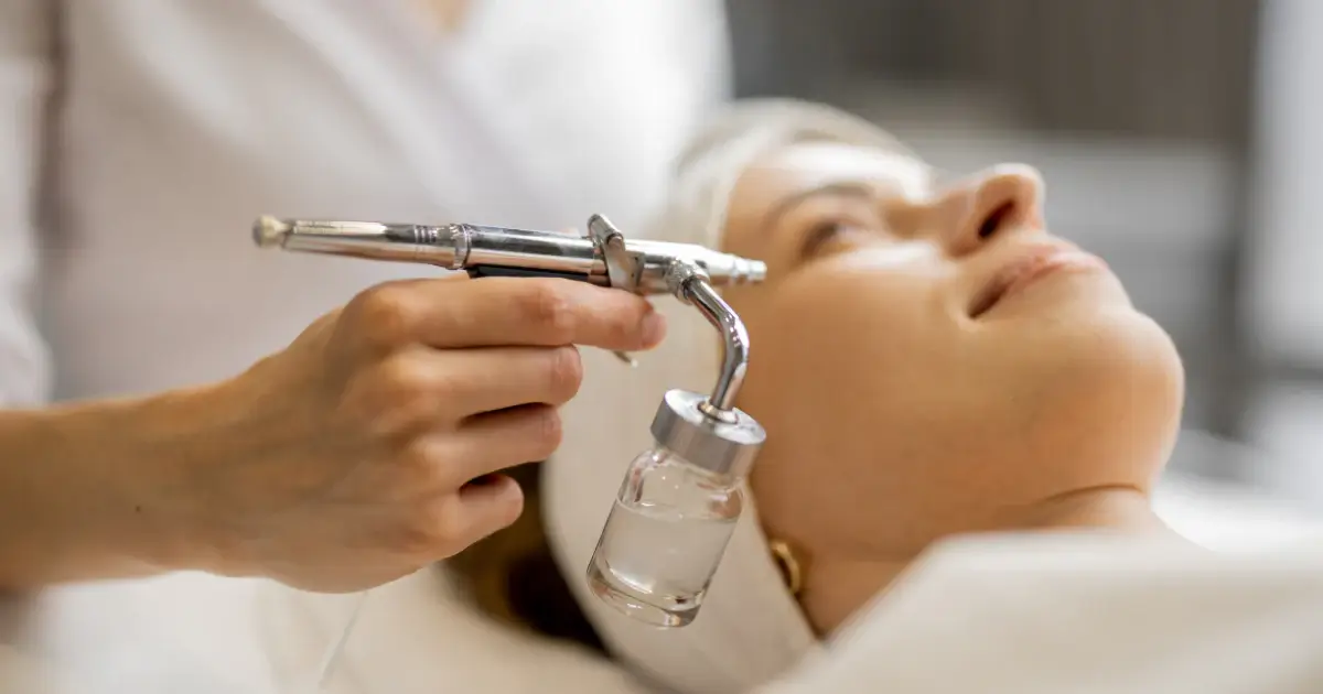 A female salonoist doing Oxygen Spray Facials with advance tools